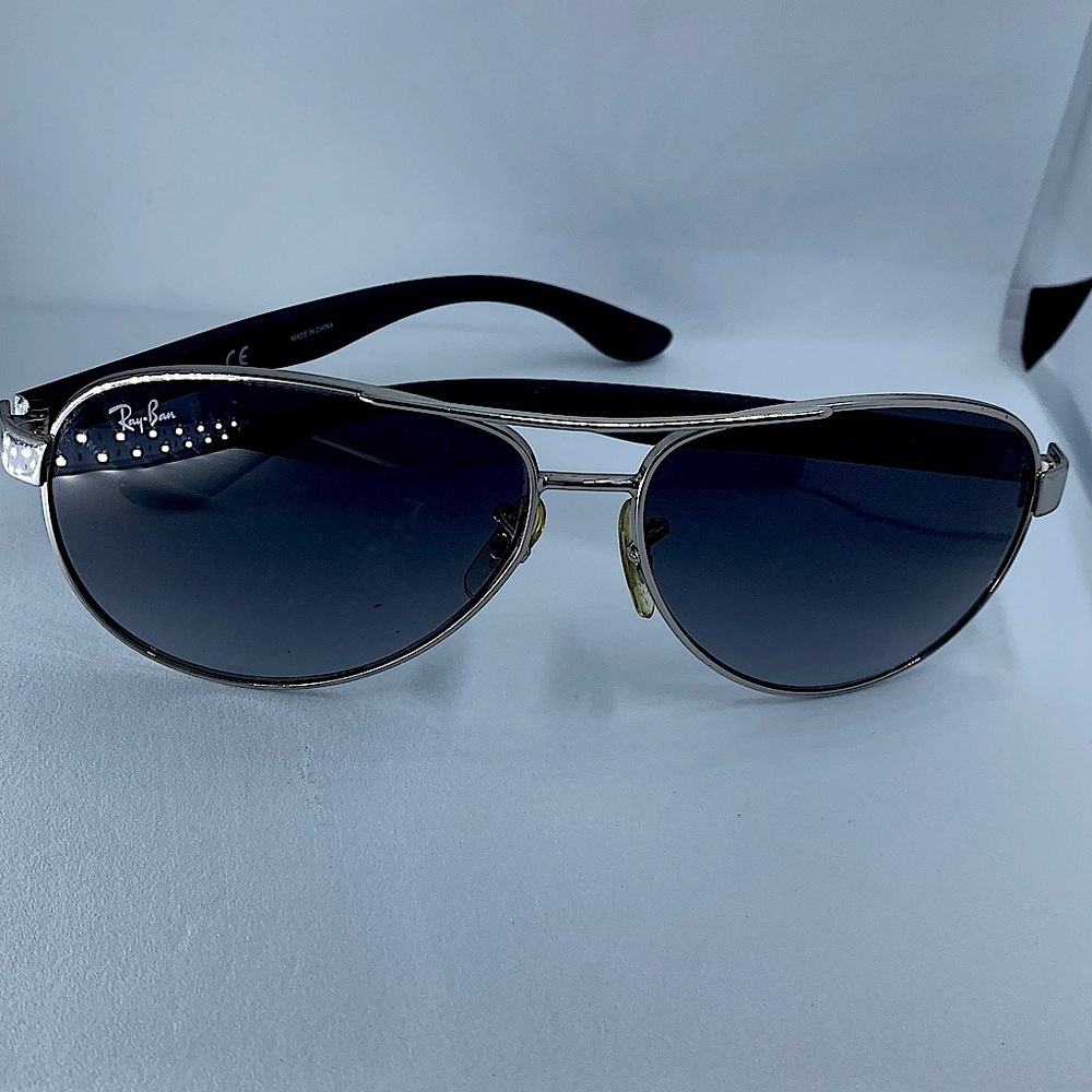 Ray-Ban Aviator Sunglasses. Light black lenses. Black bows with silver frames.